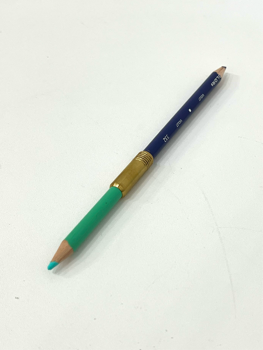 Brass pencil extender connecting two different colored pencil crayons