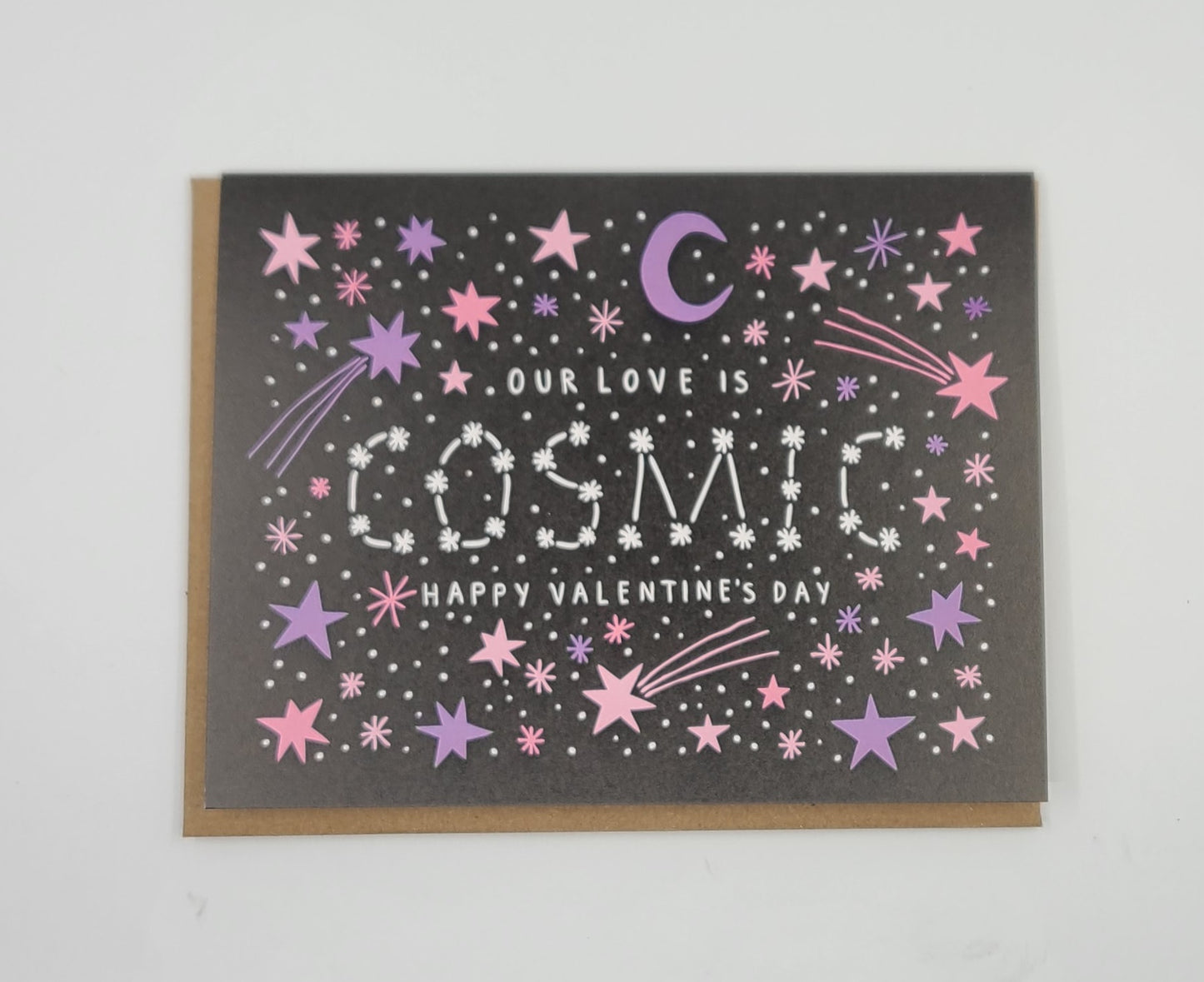 Valentine's Day card stating "Our love is cosmic" with star and moon designs on a black background