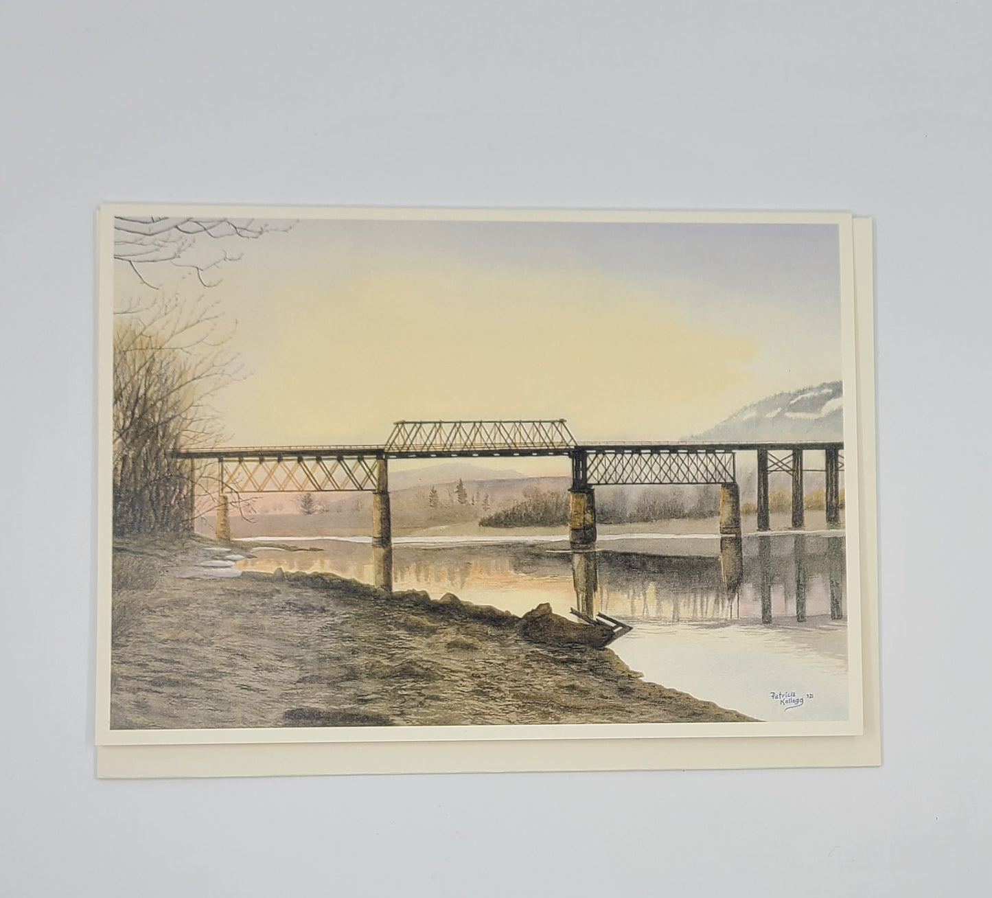 Art print of a bridge over a river with a sunset or sunrise sky.