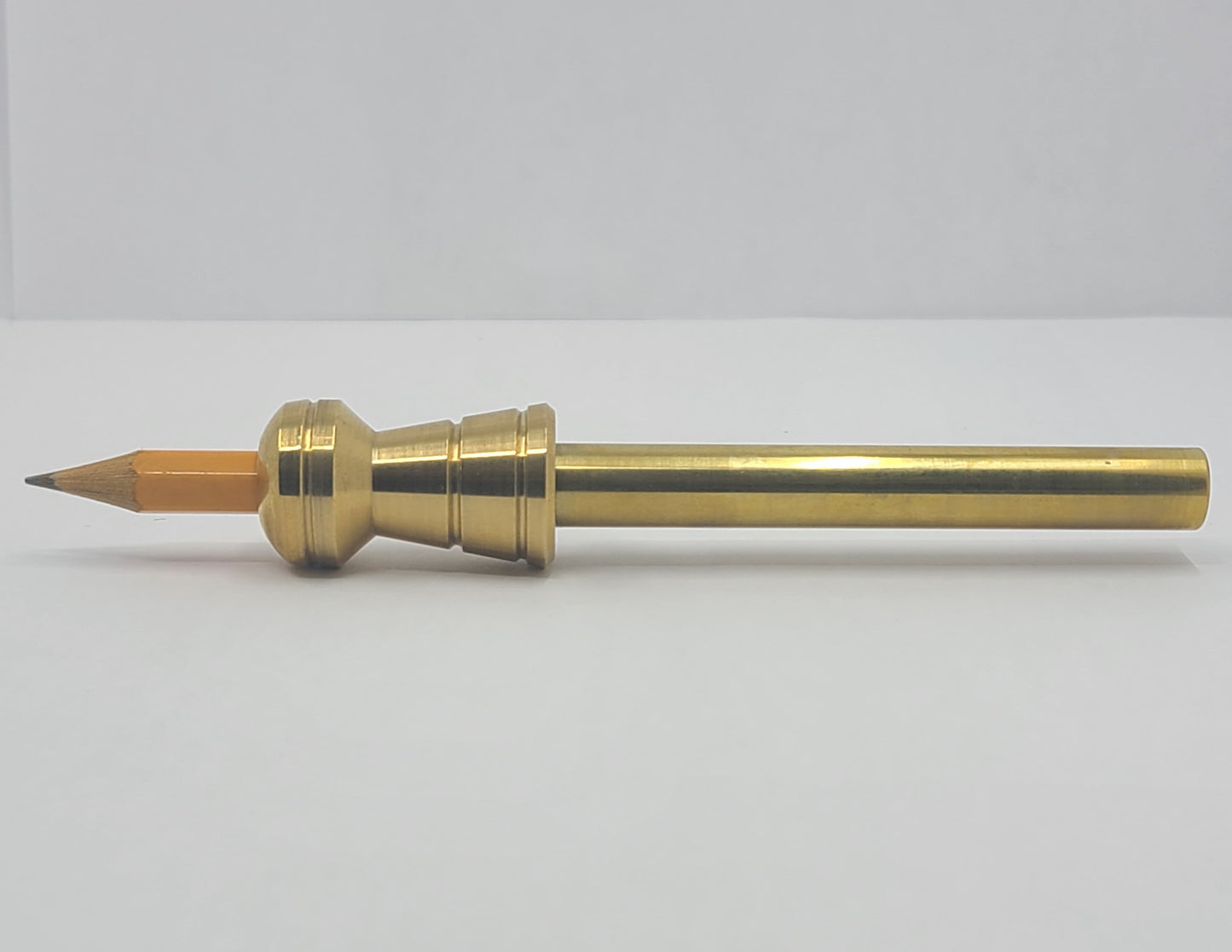 Brass pencil on a white background