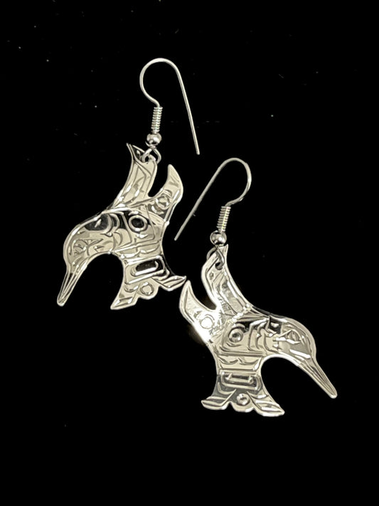 Pair of silver hummingbird-shaped earrings on a black background