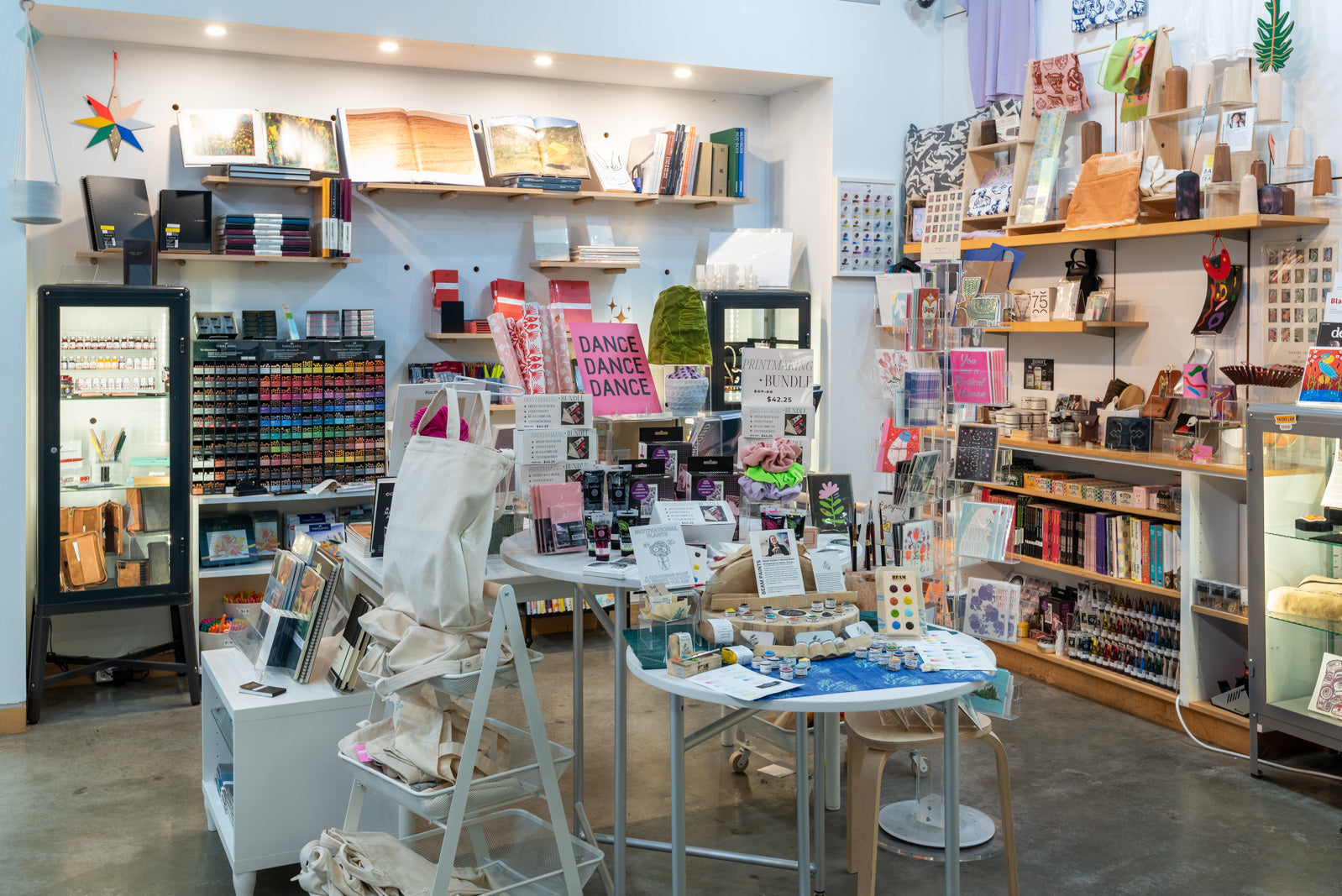 A white walled shop filled with colorful and interesting artistic objects.