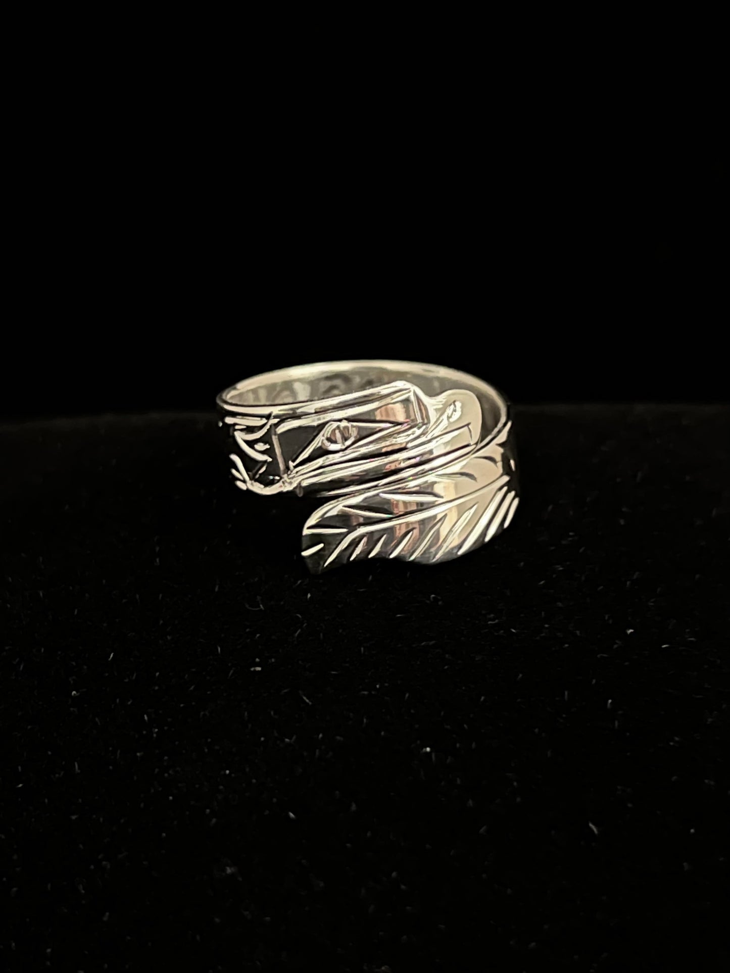 Silver ring with eagle design on a black background