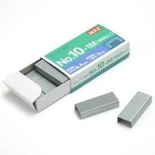 A open pack of staples with some layed out on the ground on a white background.