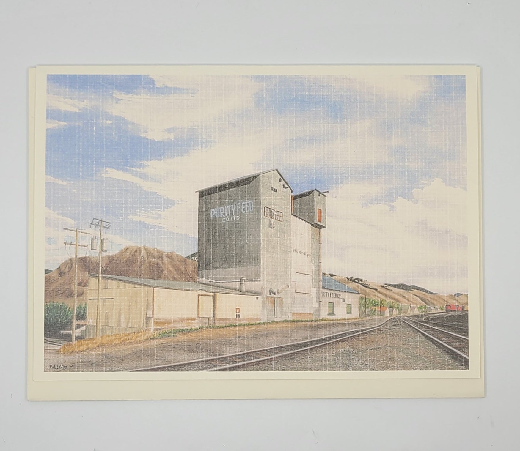 Artistic depiction of a grain elevator with mountains and tracks in the background.