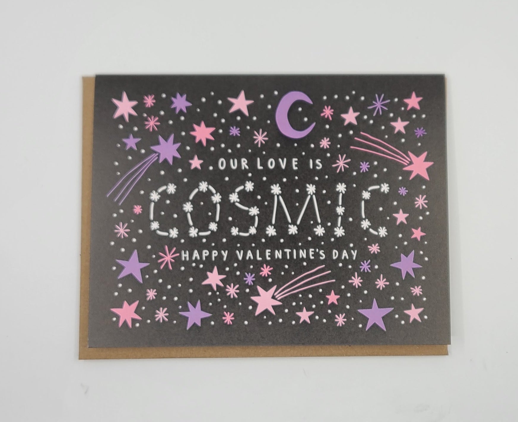 Valentine's Day card stating "Our love is cosmic" with star and moon designs on a black background