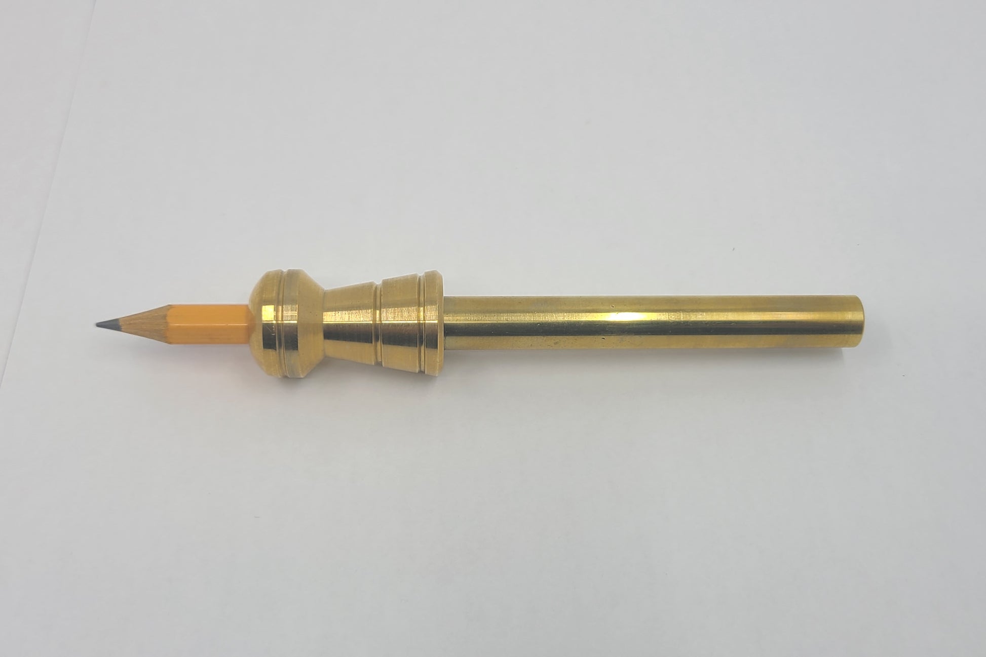 Brass pencil on a white background