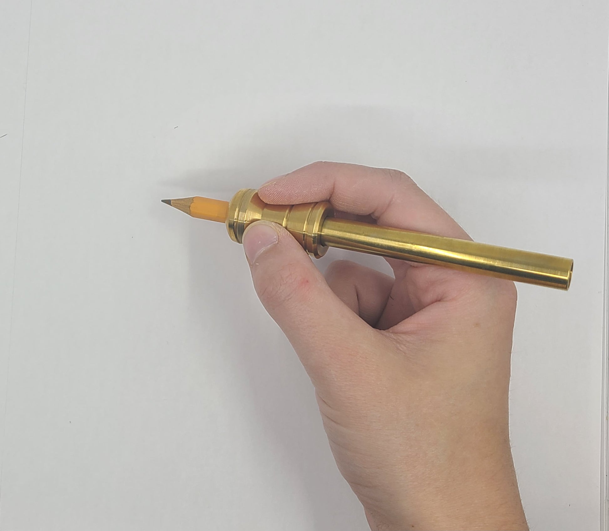 Hand holding a gold pen against a white background