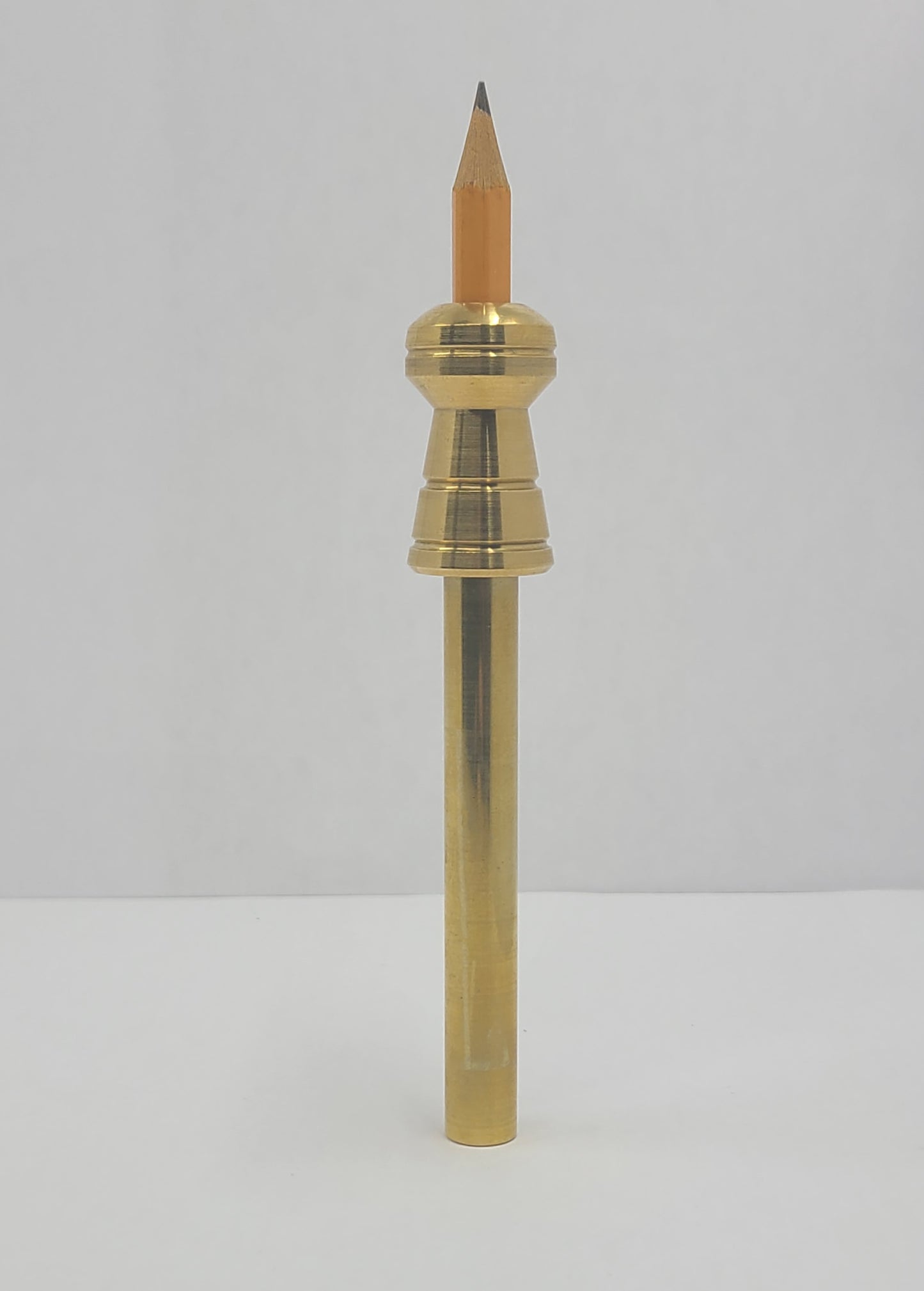 Brass pen with a wooden tip on a light gray background