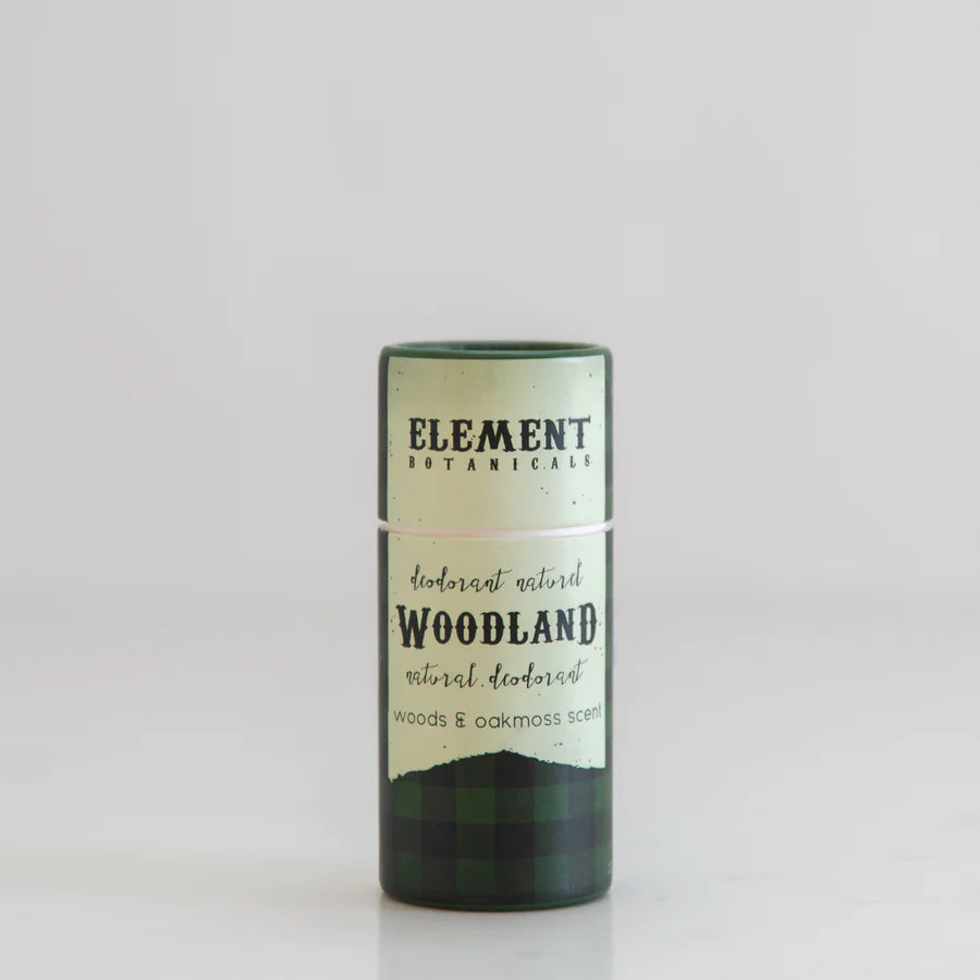 A green tube of deodorant named 'Woodland'.