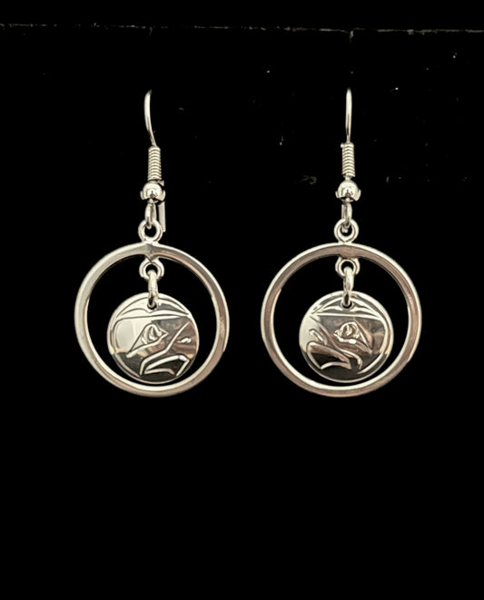 Silver hoop earrings with circular eagle designs on a black background