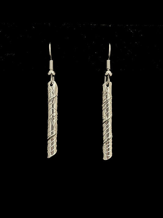 Pair of silver tube like earrings on a black background