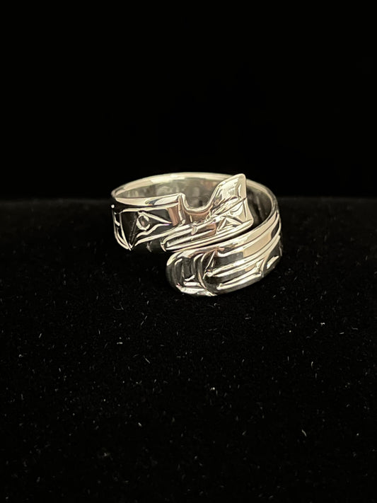Silver ring with wolf design on a black background